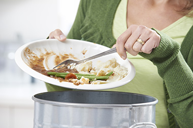 Lebensmittel Abfall, Mülleimer, Frau mit Gabel entsorgt Rest