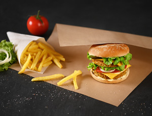 Pommes Frites und Burger in Spitztuete und Burgerpapier