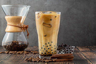 Bubble Coffee - Kaffee Milch Tapiokaperlen Holztisch Kaffebohnen