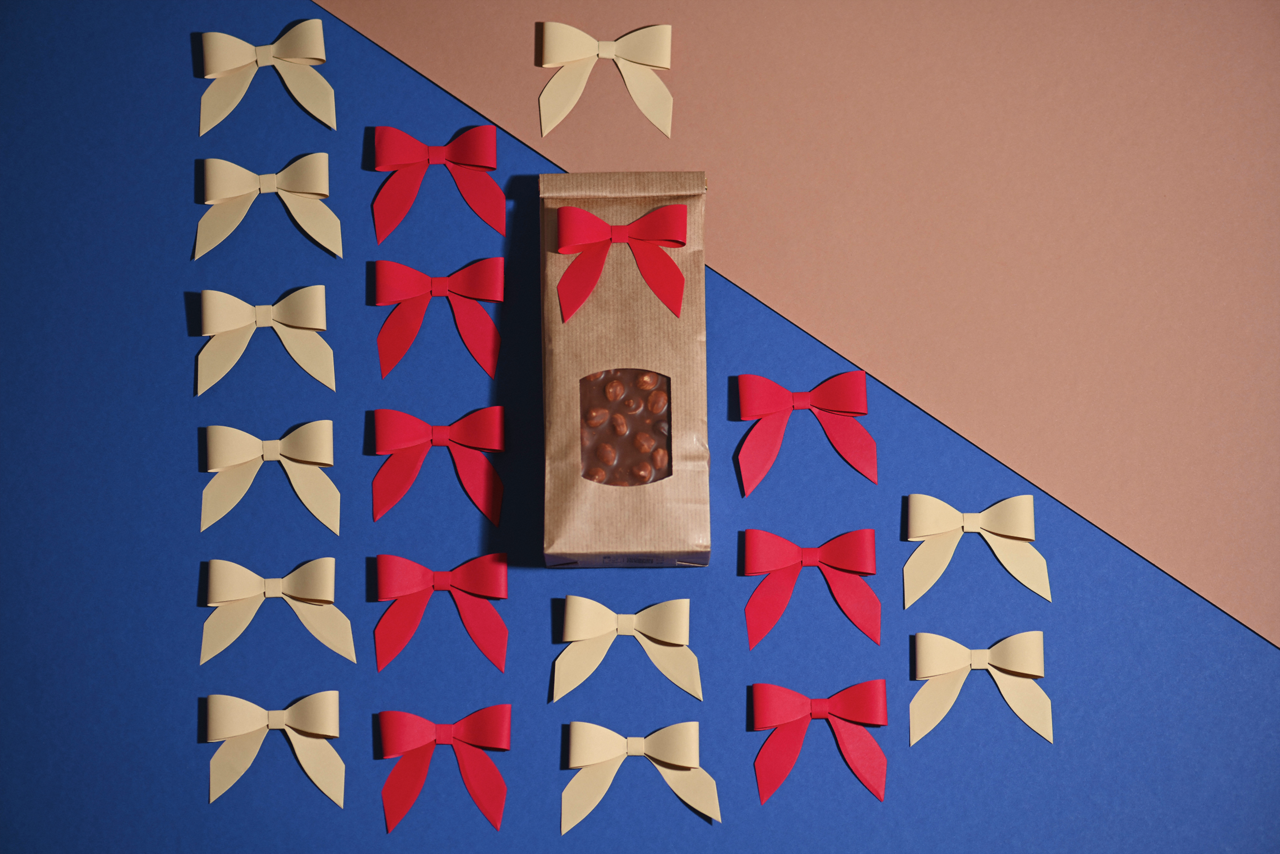 Emballage cadeau avec nœud décoratif, collé  fixé par un point adhésif.