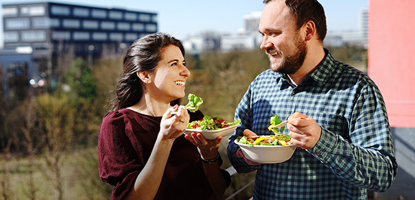 2 Personen essen Salat aus To-go-Verpackung