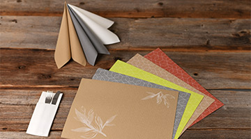 Servietten, Tischsets und Besteck auf Holztisch