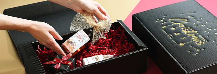 schwarze Flaschen-Geschenkverpackung mit rotem Füllmaterial