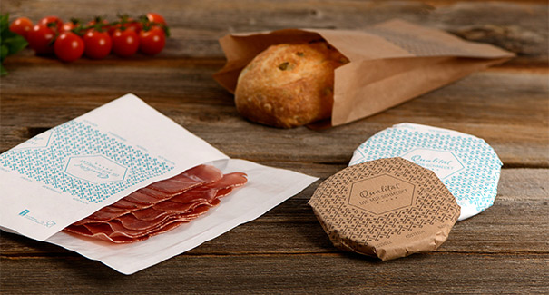 Metzgerpapier mit Wurstwaren auf Holztisch Metzgerpapier mit Wurstwaren auf Holztisch